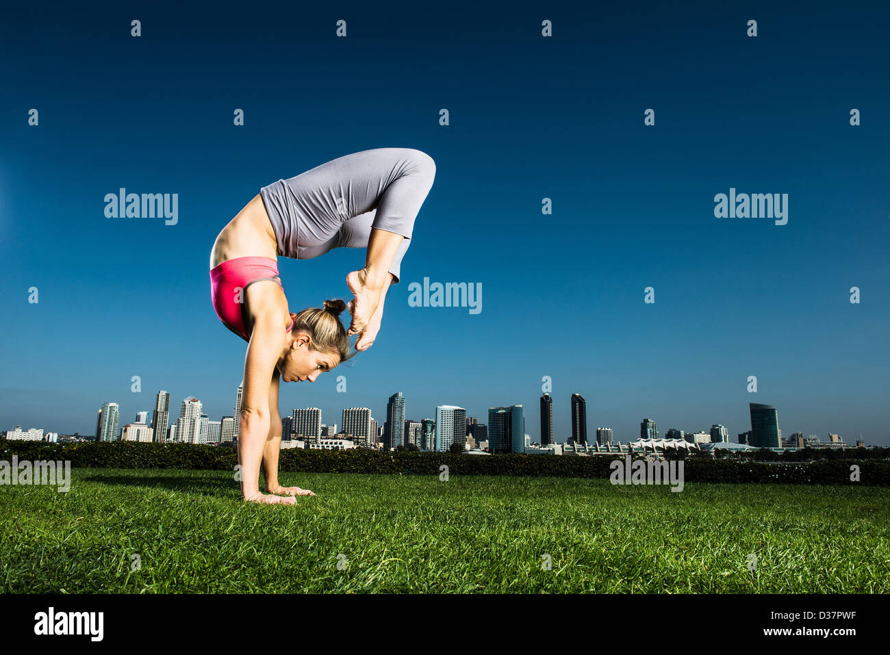 Woman practicing yoga in urban park Stock Photo