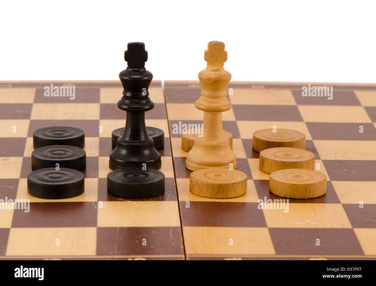 enemy chess queens stand in front surrounded by checkers on wooden board isolated on white Stock Photo