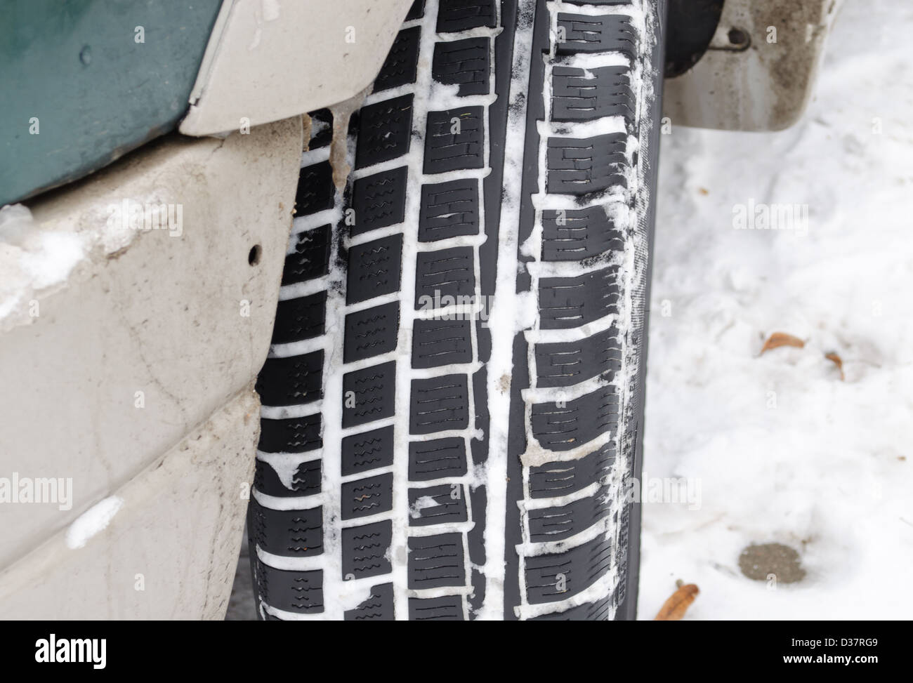 closeup of car tire tread protector full of snow in winter. Stock Photo
