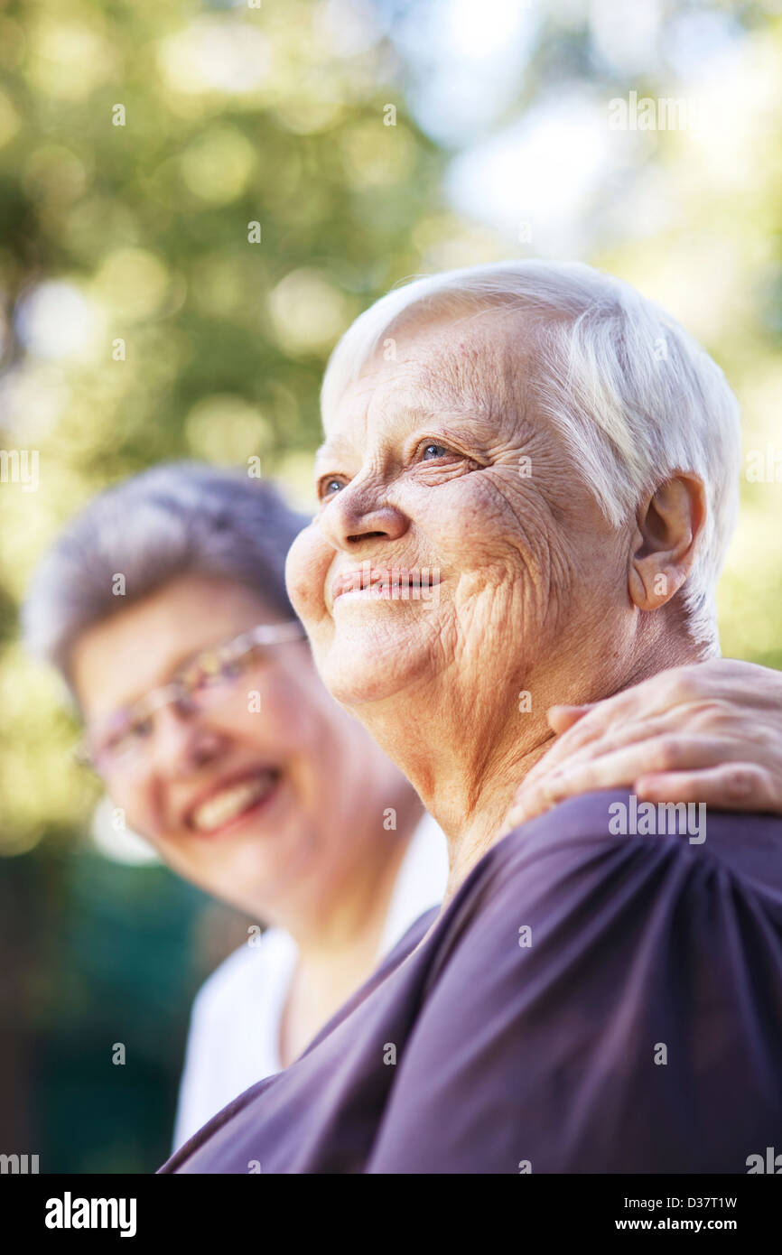 Older women smiling together outdoors Stock Photo