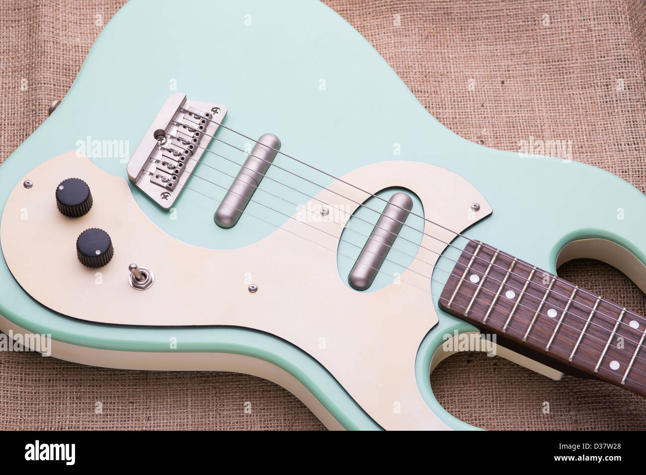 Danelectro baby blue electric guitar on a hessian sack with soft natural lighting. Stock Photo