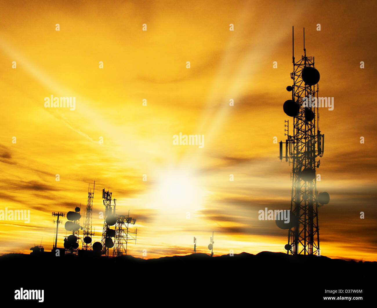 Several radio towers with sunset sky in background Stock Photo