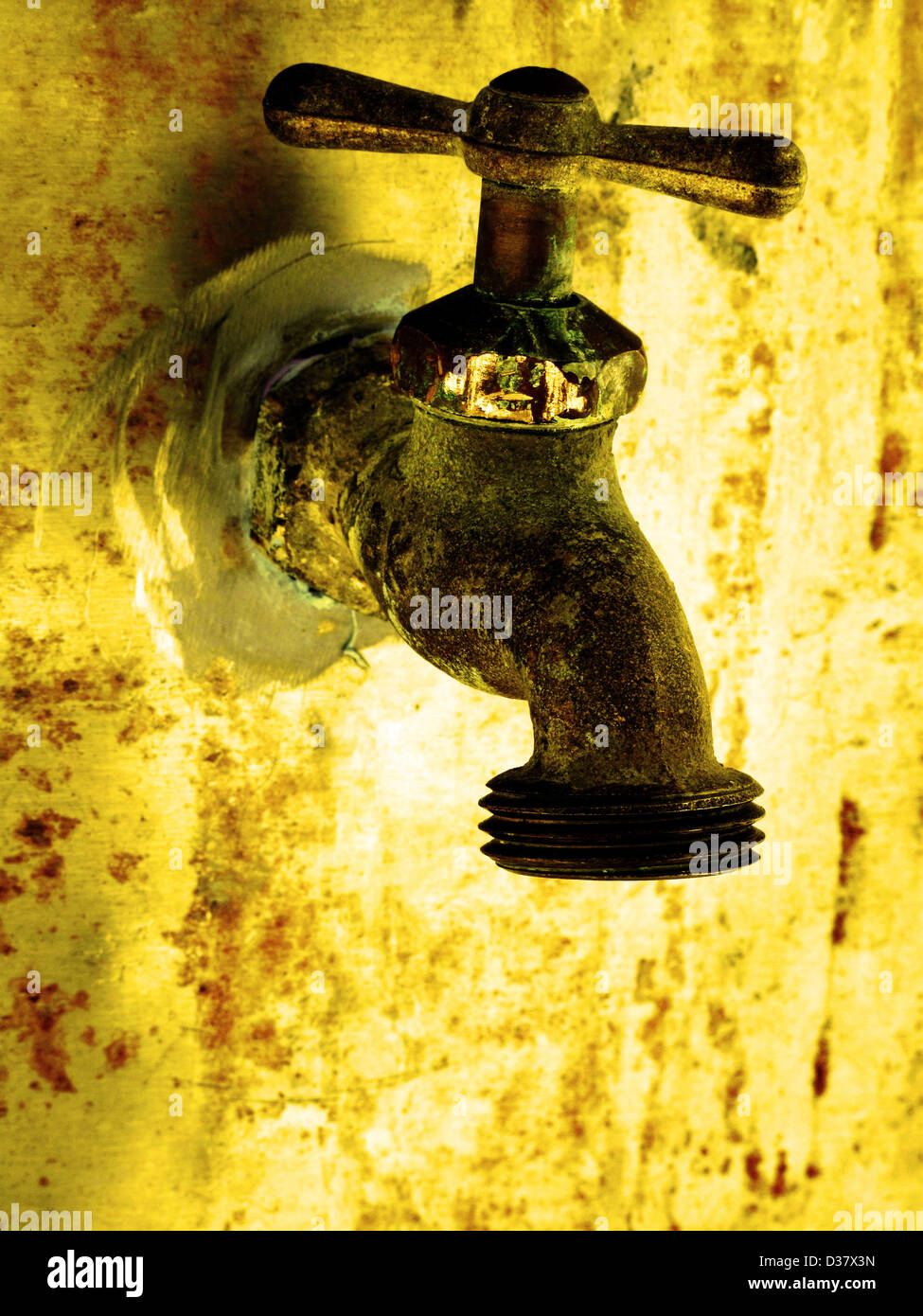 Water faucet dripping water with golden background on hot day Stock Photo