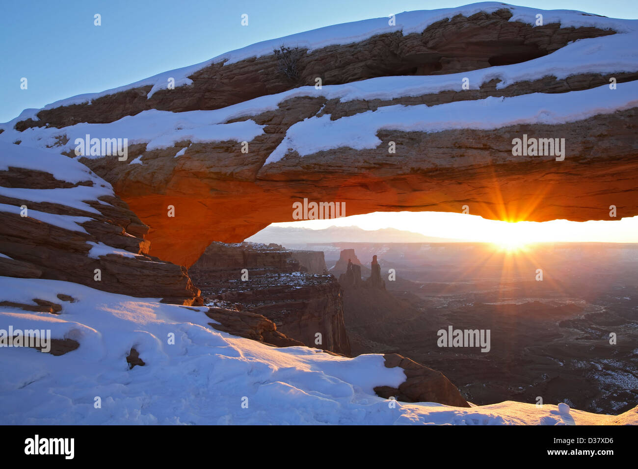 Mesa Arch covered in snow and sunburst, Island in the Sky District, Canyonlands National Park, Utah USA Stock Photo