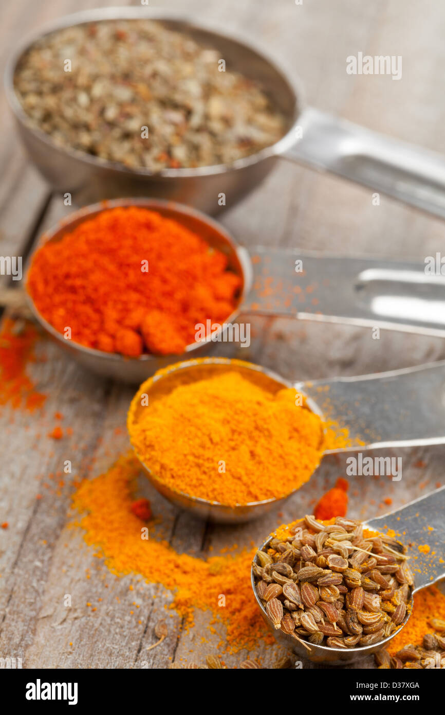 Various mixed spices (oregano, curcuma, paprika, anise) in metal scoops
