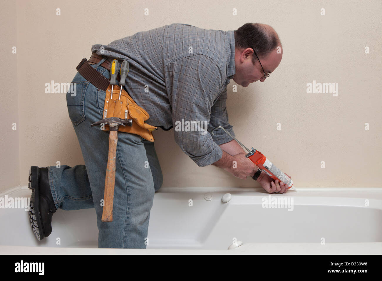 USA, Texas, Dallas, Man with Caulk Gun working in bathroom Stock Photo