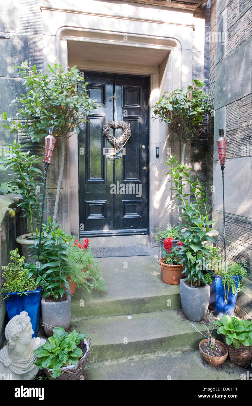 Old English black front door with flower pots Stock Photo Alamy