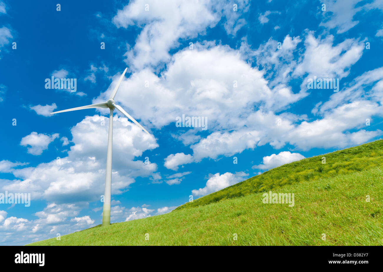 wind turbine on a hill under a cloudy blue sky Stock Photo - Alamy