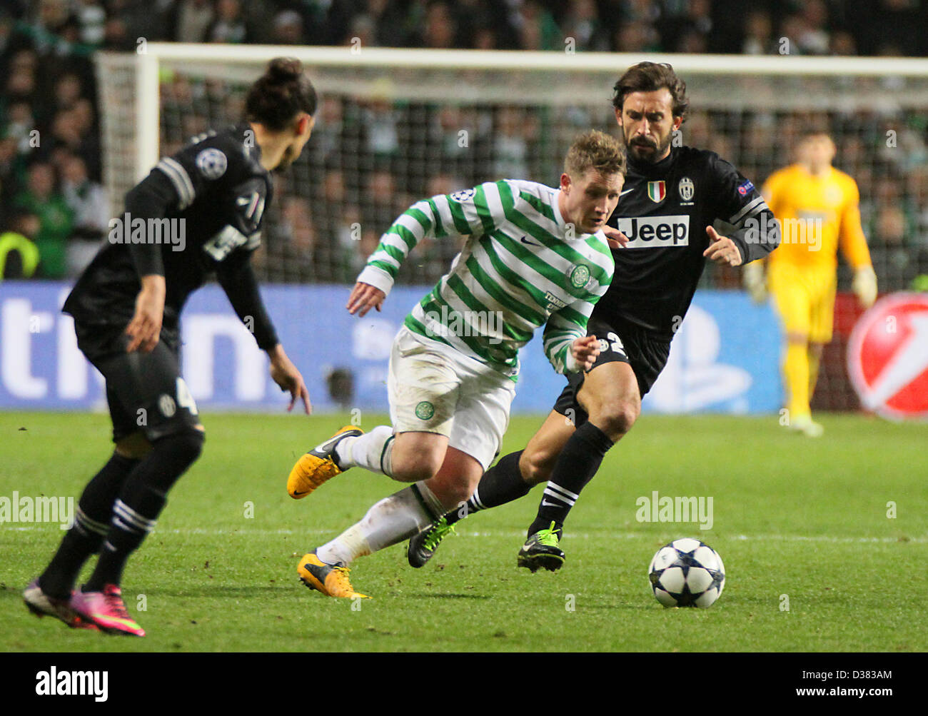 Glasgow, Scotland, UK. 12th February 2013.  Andrea Pirlo and Martin Caceres try to stop Kris Commons advancing during the Champions League game between Celtic and Juventus from Celtic Park. Credit: Action Plus Sports Images / Alamy Live News Stock Photo