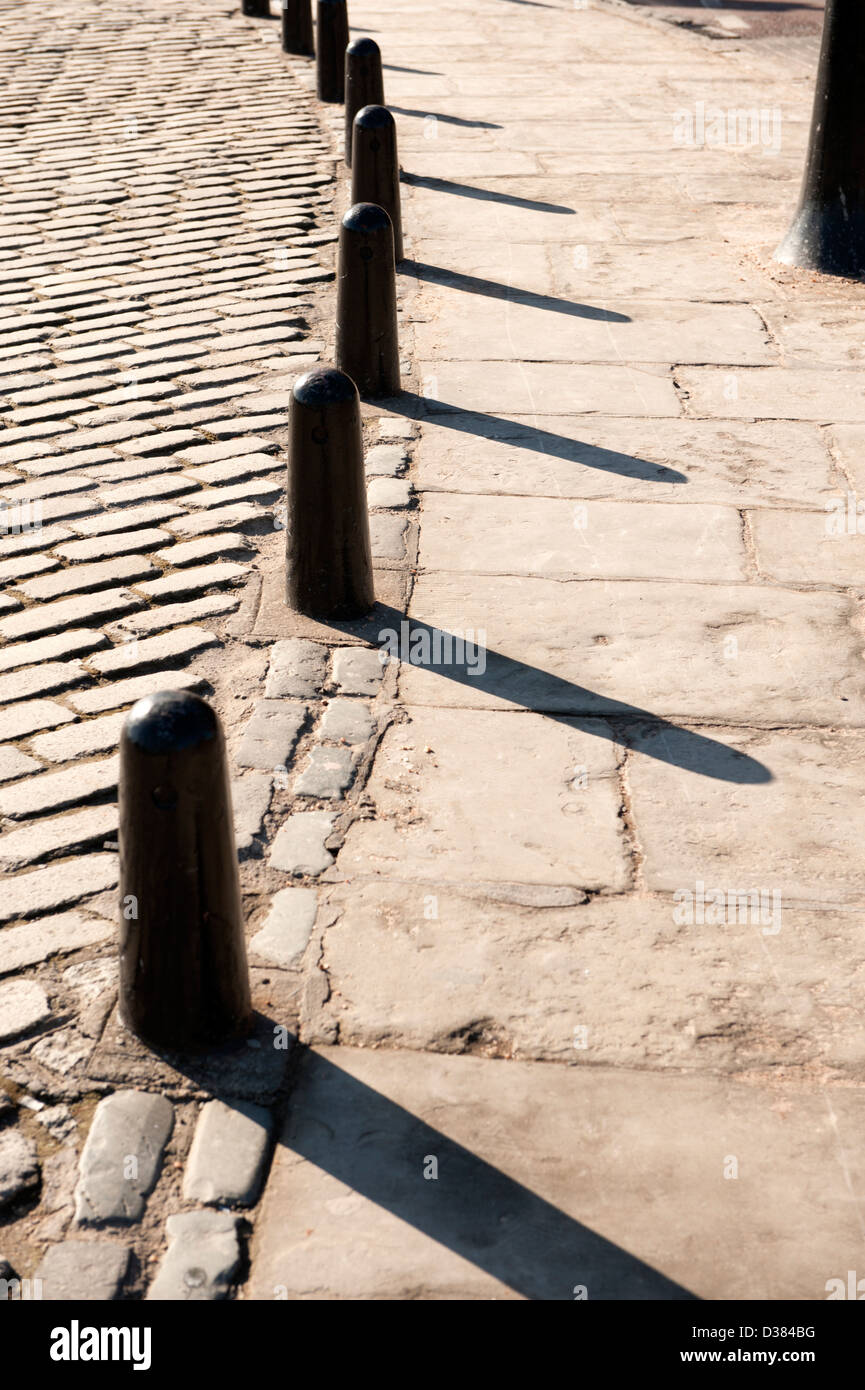 Cast Iron Bollards and strong shadows in sunshine Stock Photo