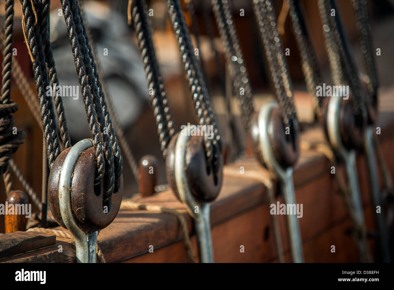 Looking along a row of tackle blocks and the rigging of a 19th century tall ship. Selective focus. Stock Photo