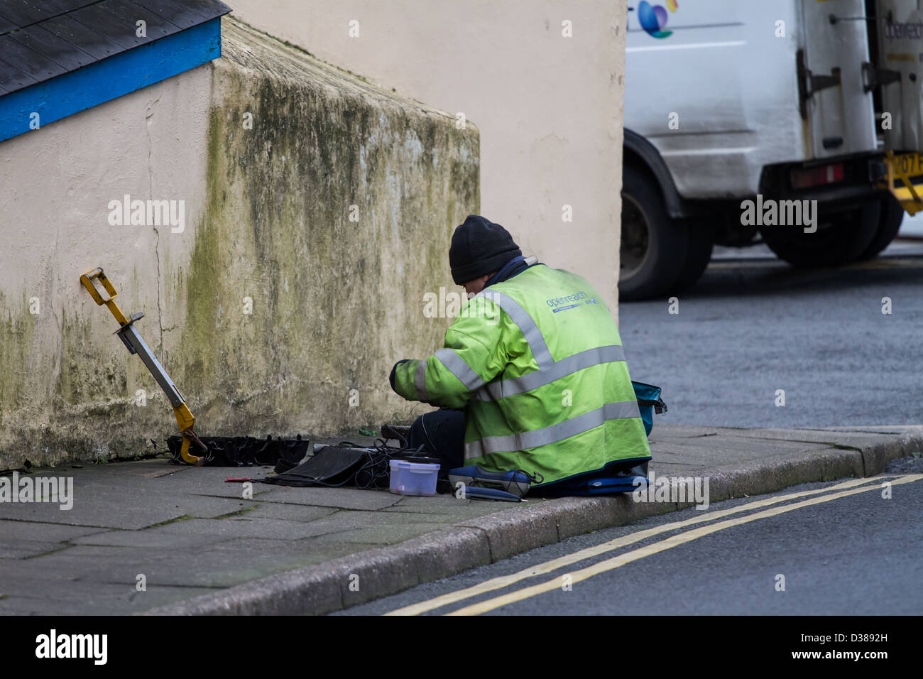 Man at work by  hole in the pavement Stock Photo