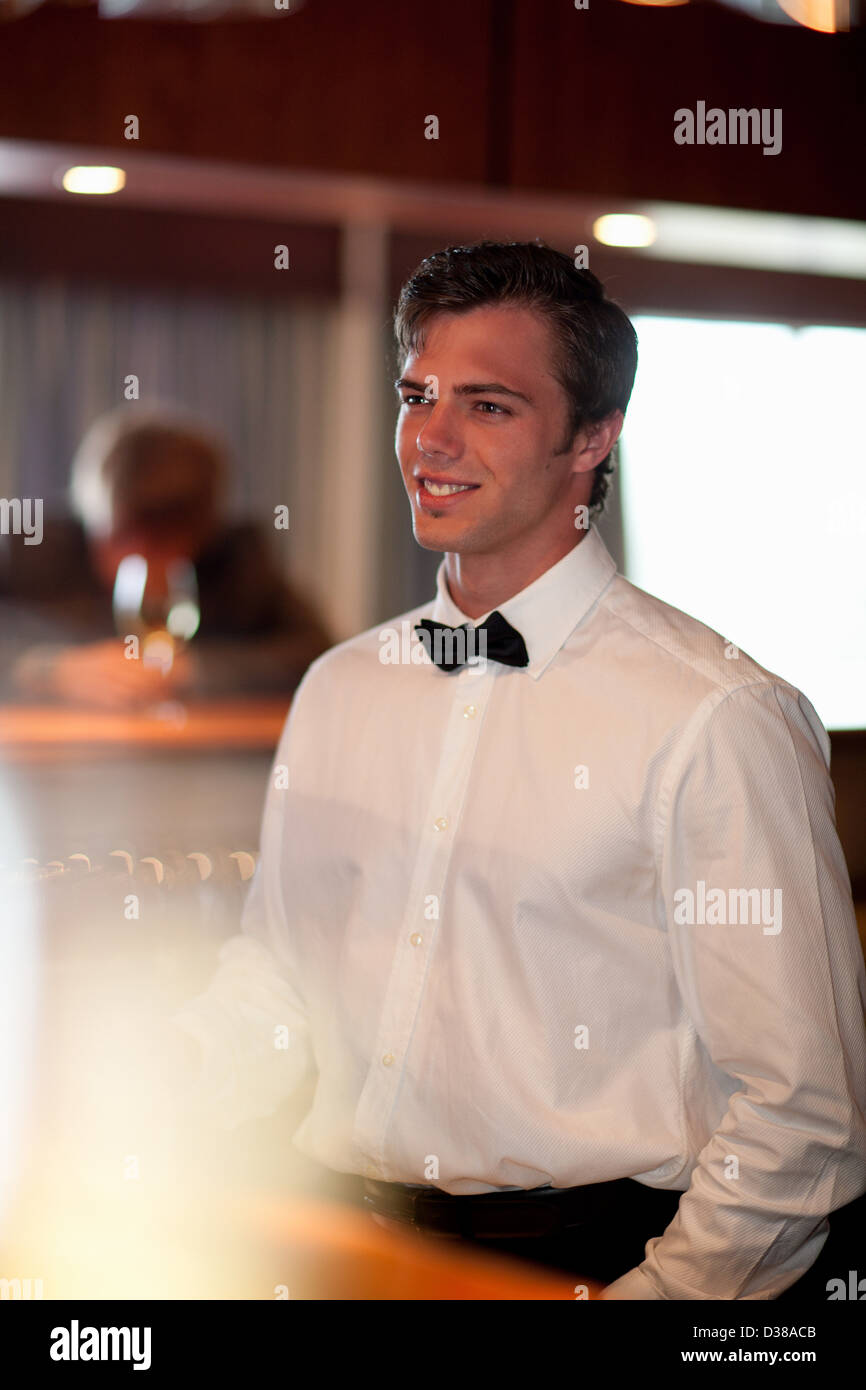 Waiter standing behind restaurant bar Stock Photo Alamy