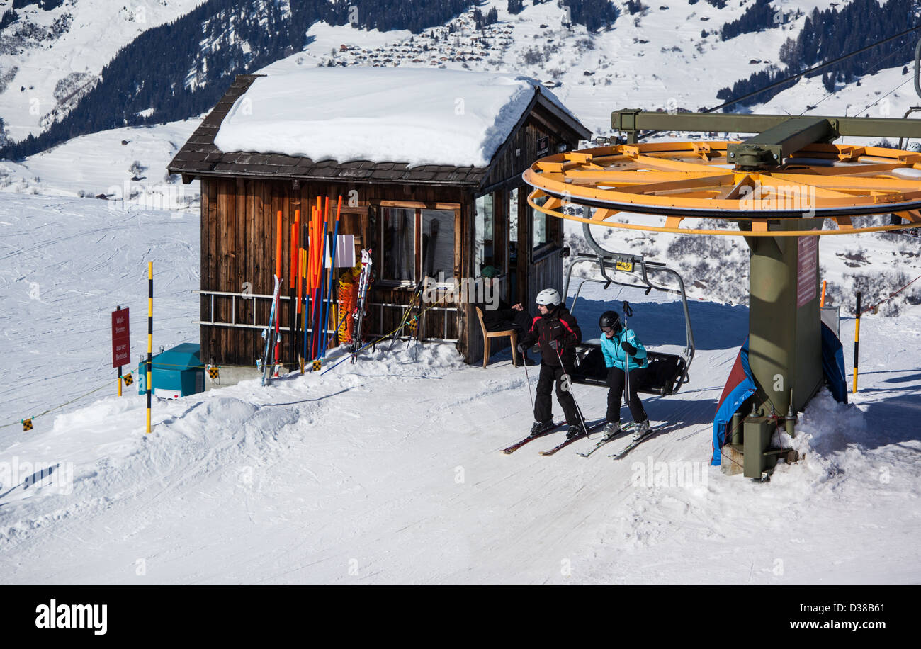 SKiers exiting chairlift at arrival station, Obersaxen, Grisons, Switzerland Stock Photo