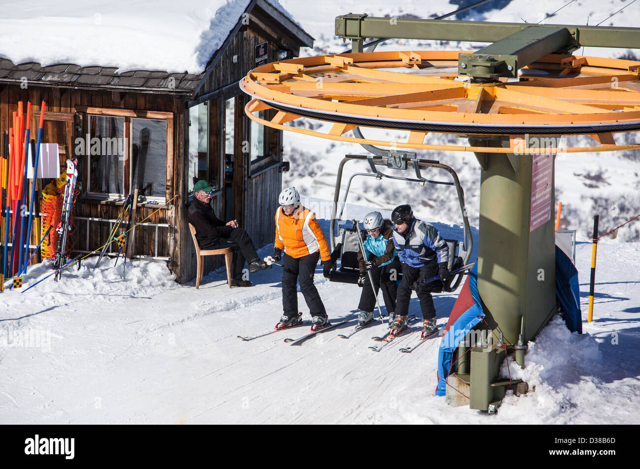 SKiers exiting chairlift at arrival station, Obersaxen, Grisons, Switzerland Stock Photo