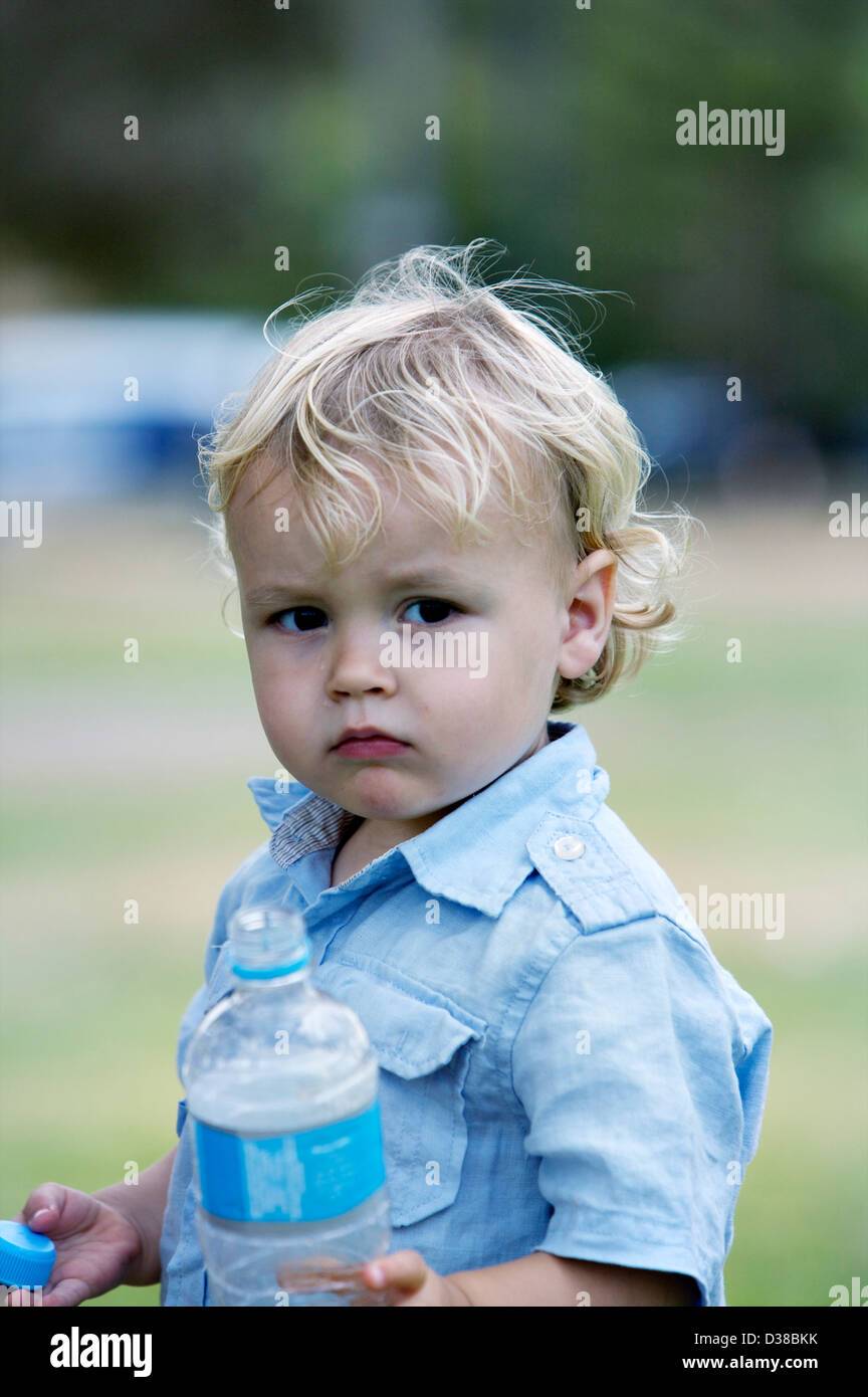 Small Boy With Blond Hair And Brown Eyes Wearing A Blue Shirt