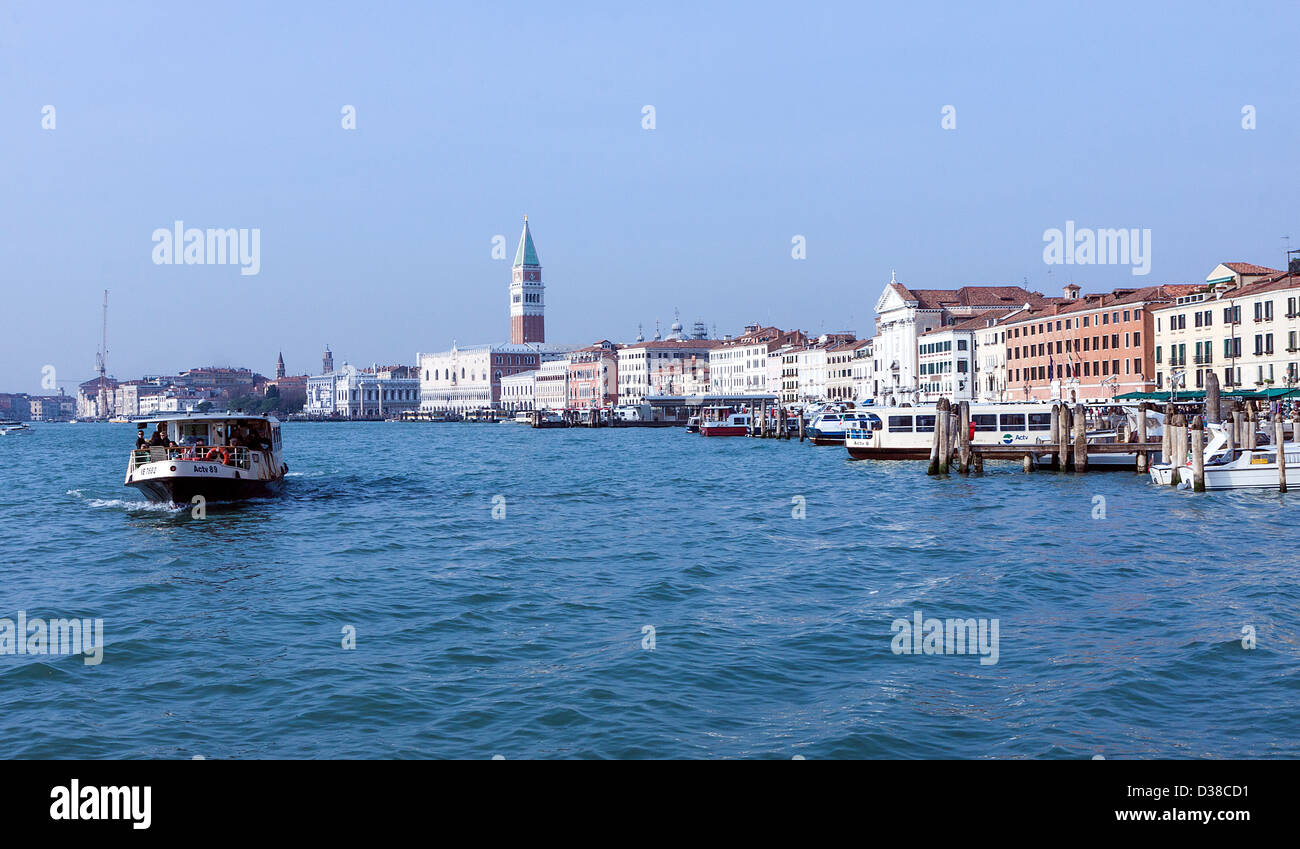 A Venitian water taxi makes its way along the Canale di San Marco in the sunshine with St Mark's Campanile in the background. Stock Photo