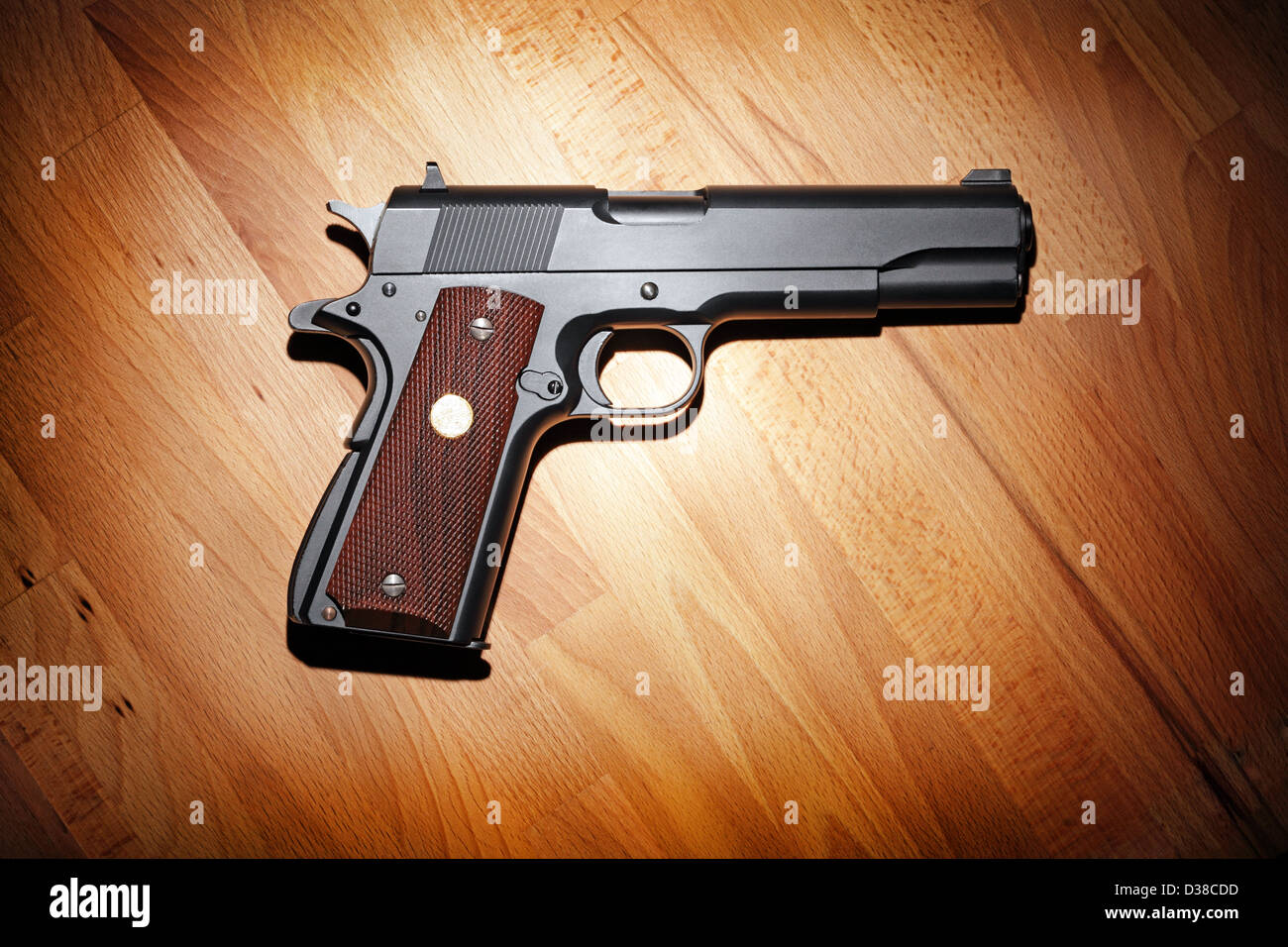 Semi-automatic M1911 Mark IV Series 80 .45 caliber pistol on the wooden table. Stock Photo