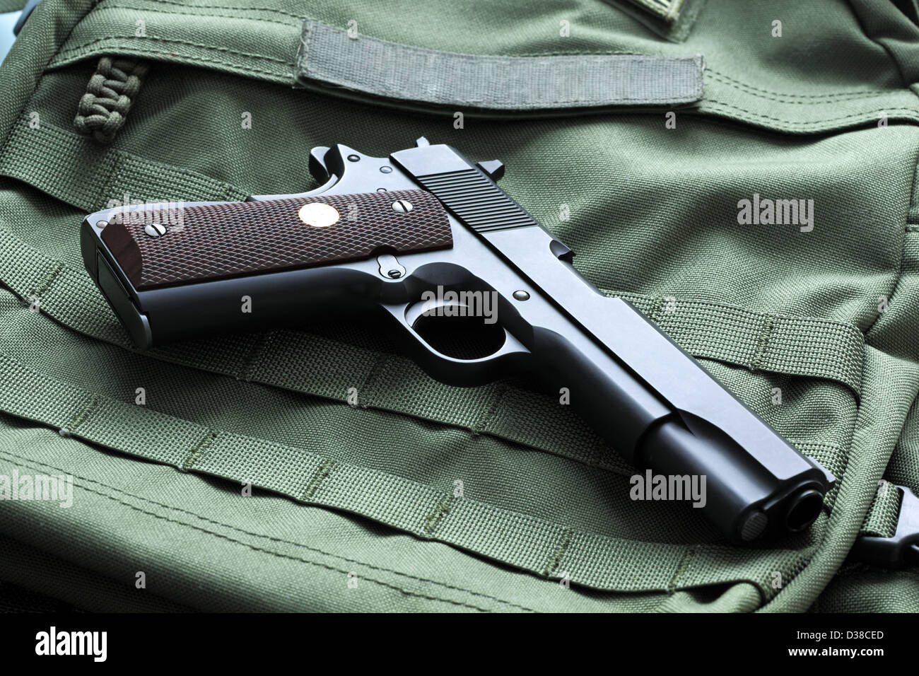 Legendary semi-automatic M1911 Mark IV Series 80 .45 caliber pistol on a green background Stock Photo