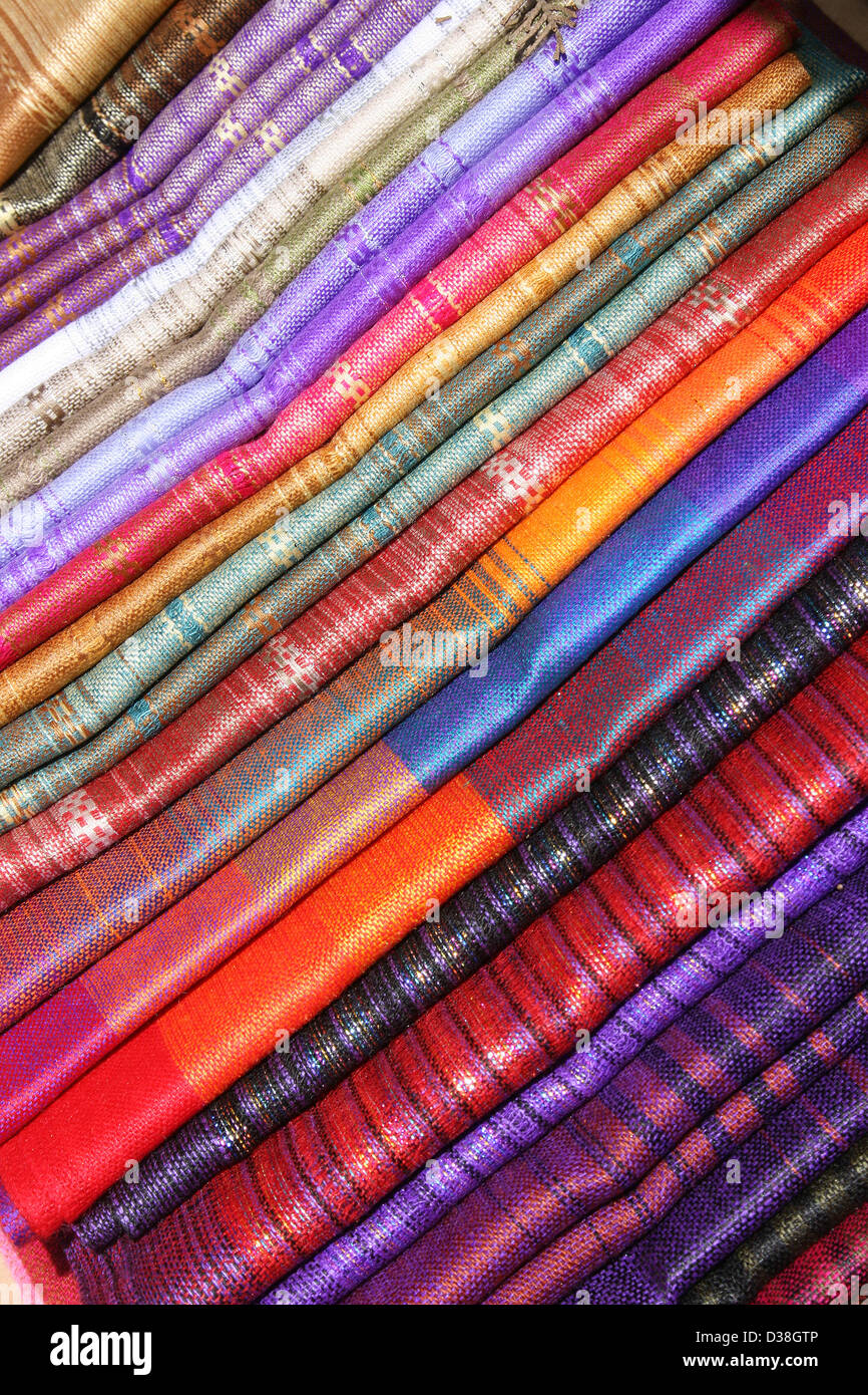 Stacked handmade linens for sale at the outdoor craft market in Otavalo