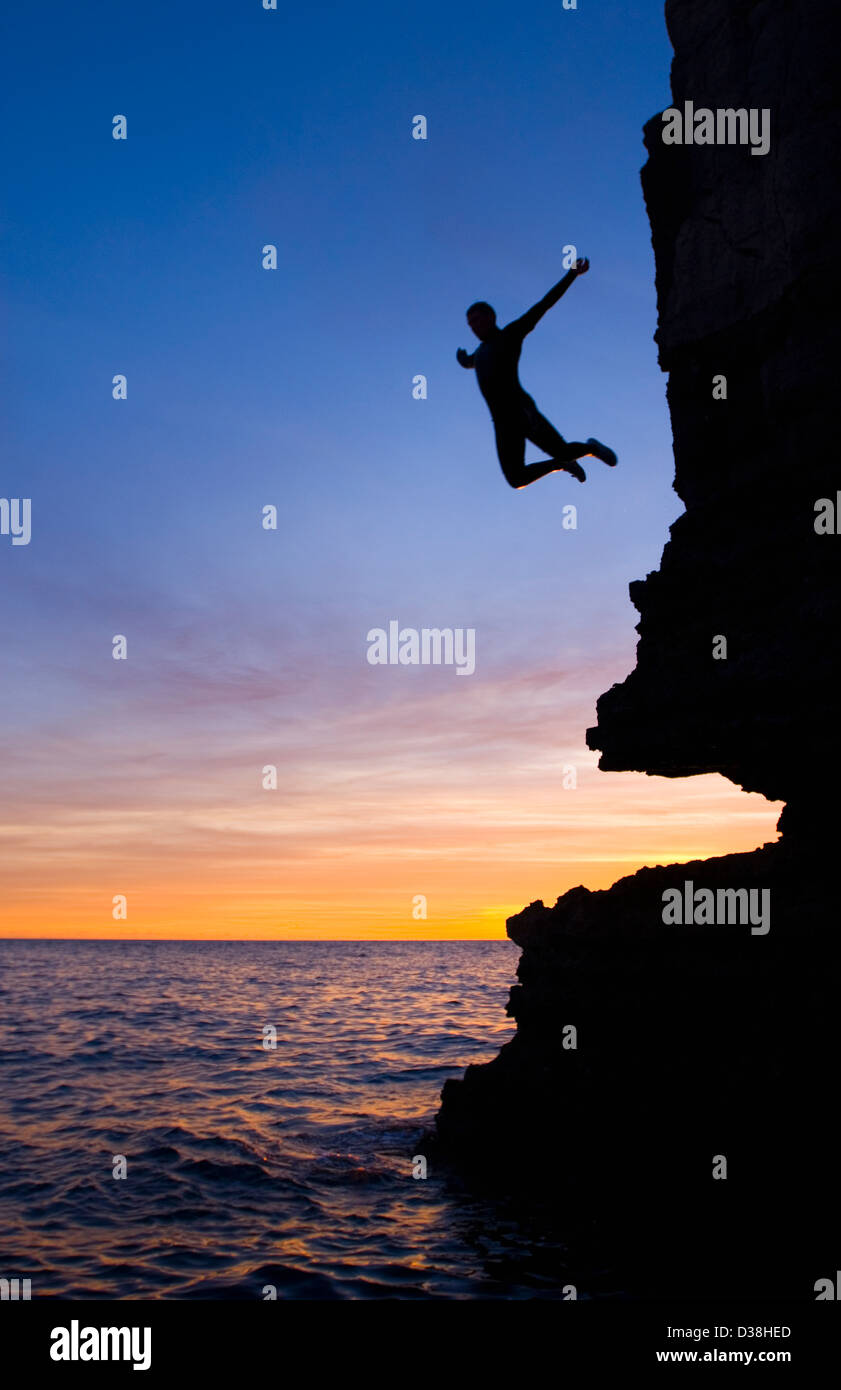 Silhouette of man cliff diving Stock Photo