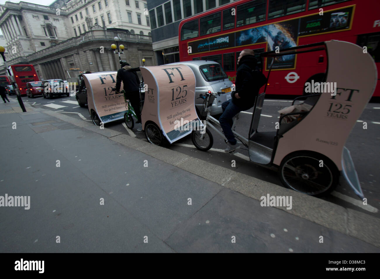 London, UK. 13th February 2013. Newspaper vendors on rickshaws distribute free copies of the first Financial Times in the city of London financial district. The Financial Times was first published on 13 February 1888 and celebrates its 125th anniversary with a special edition. Amer Ghazzal / Alamy Live News Stock Photo