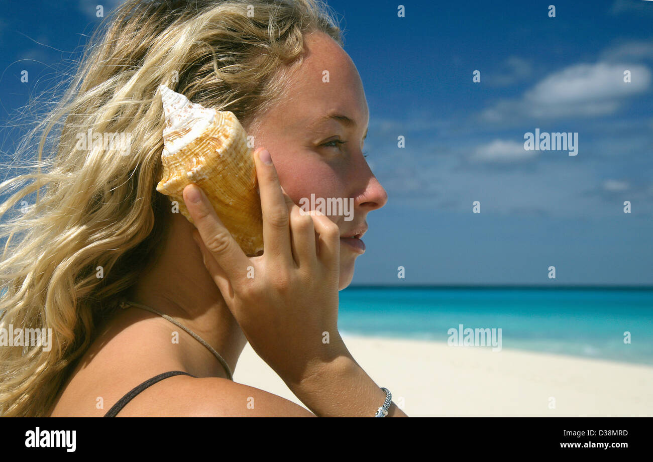 Woman holding conch shell ear hi-res stock photography and images - Alamy