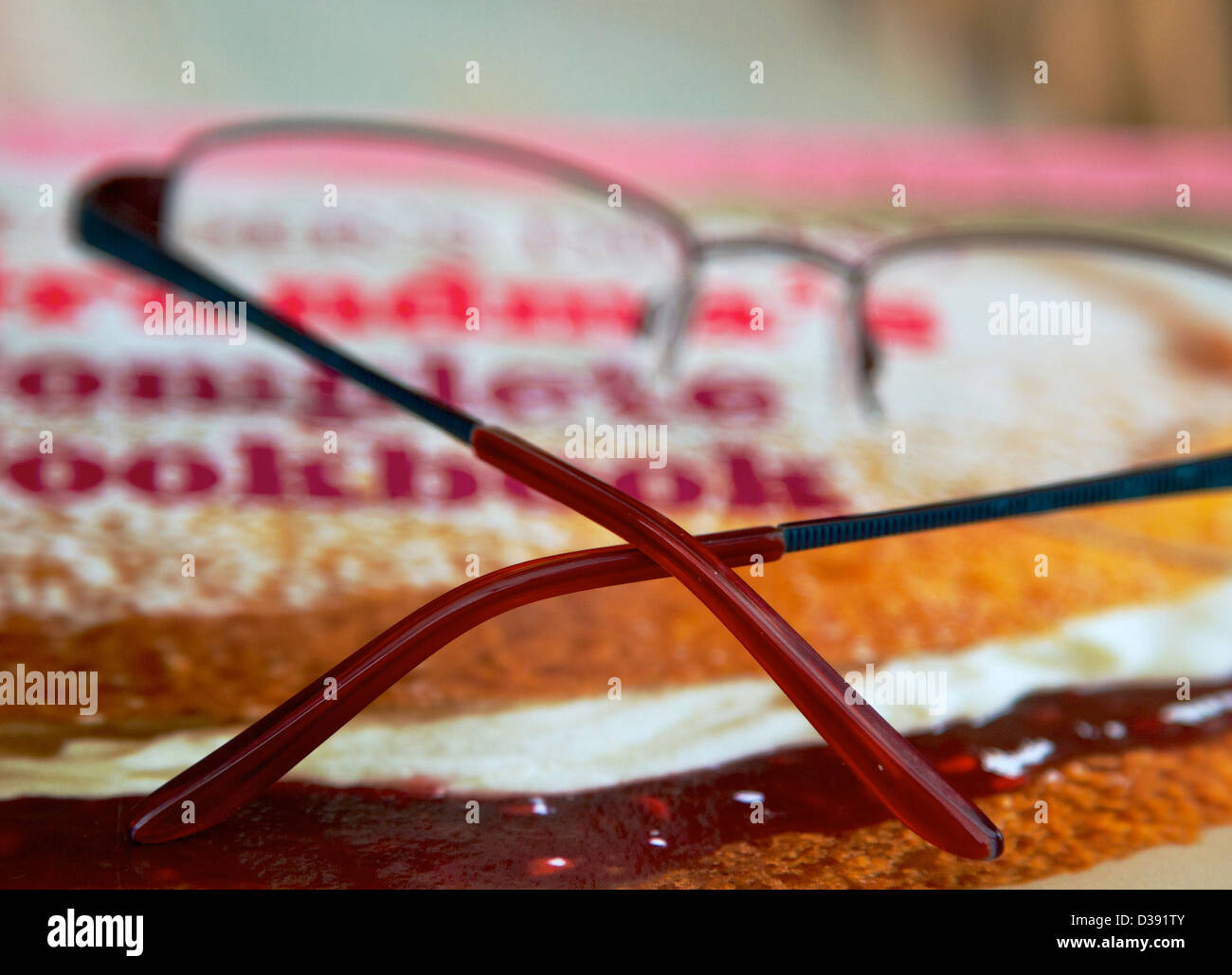 reading glasses resting on cookery book Stock Photo