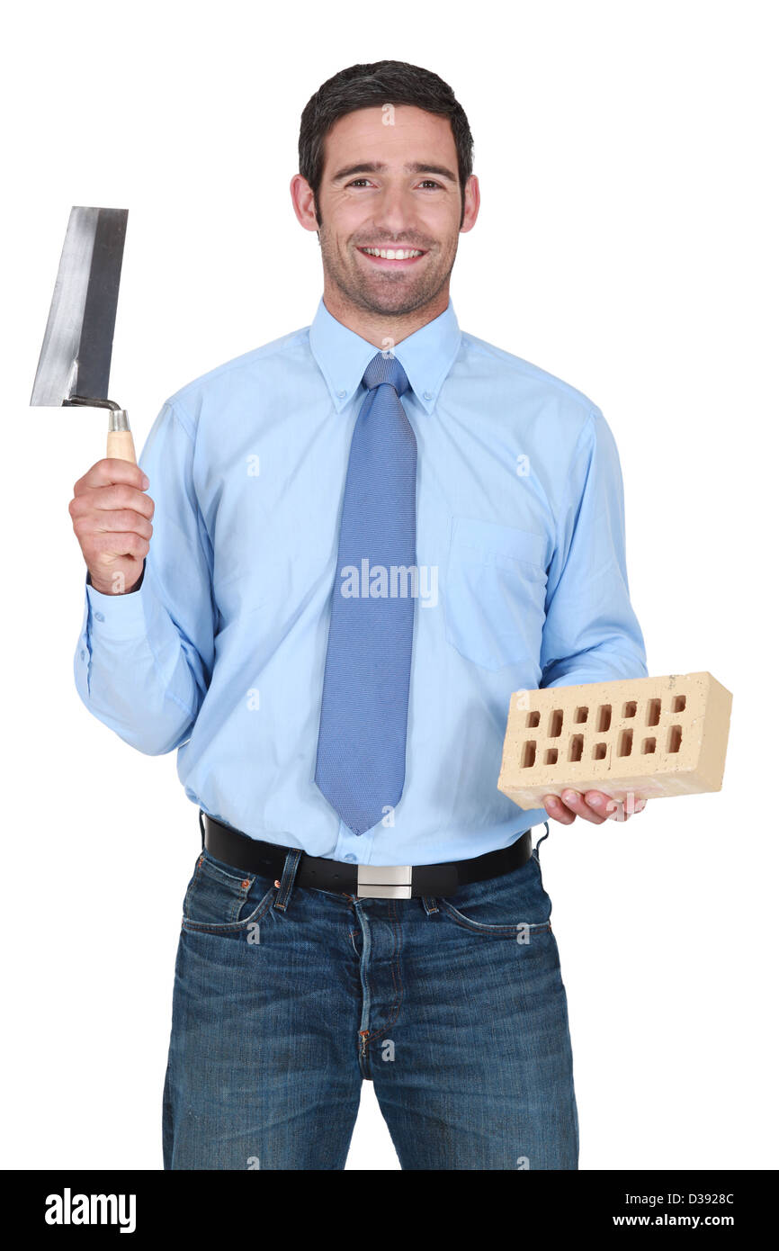 Man holding a brick and a trowel Stock Photo - Alamy