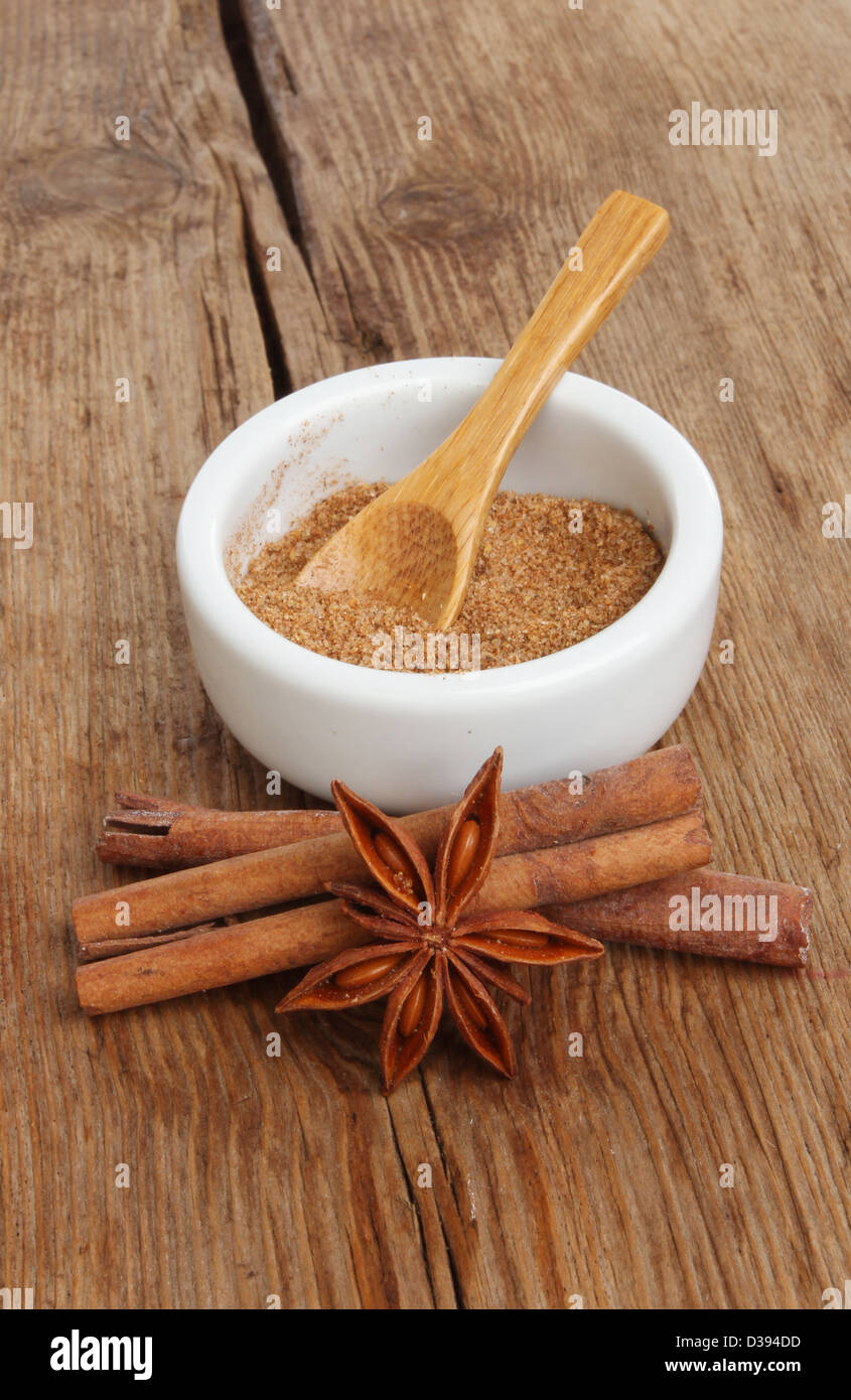 Chinese five spice in a ramekin with star anise and cinnamon sticks on a background of old weathered wood Stock Photo