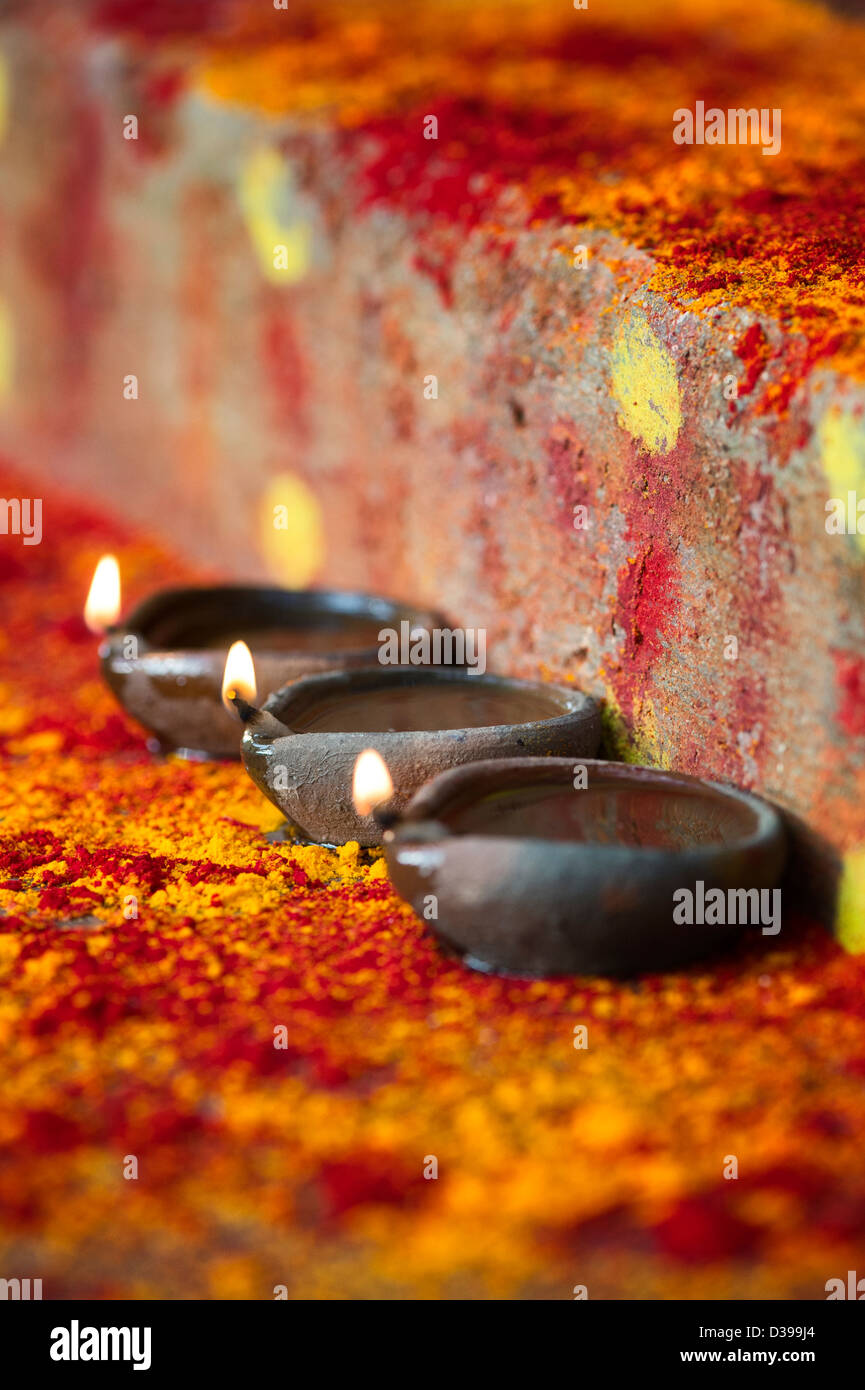 Oil Lamps on the steps of a rural indian village shrine / temple. India. Selective focus. Stock Photo