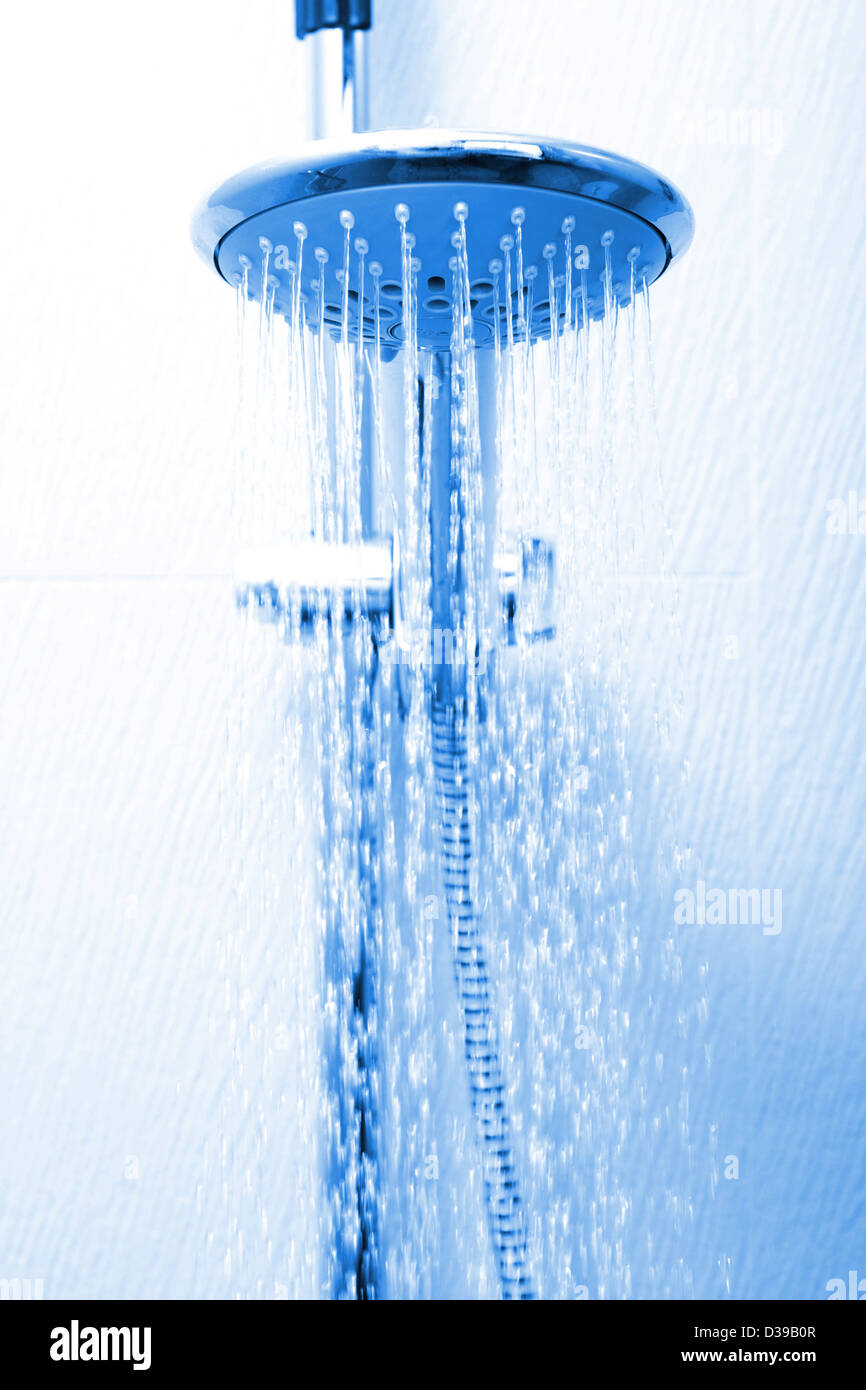 A hotel shower head flowing with water Stock Photo - Alamy