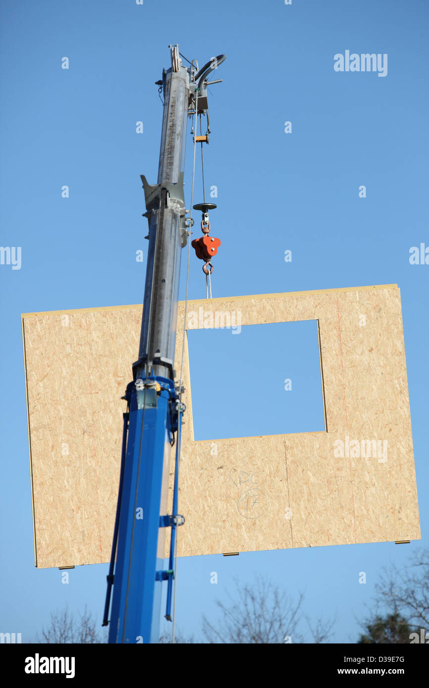 Crane lifting a section of wooden wall Stock Photo Alamy