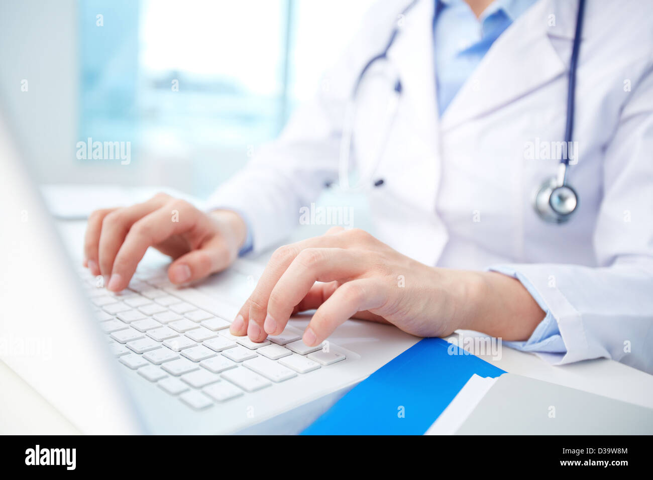 Modern clinician inputting diagnosis into an online data base Stock Photo