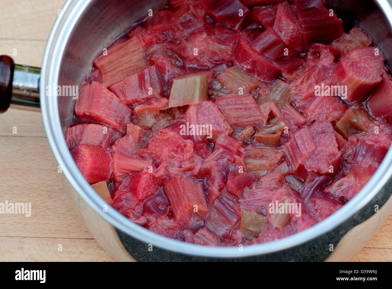 An overhead shot home grown organic rhubarb in a pan of stewed or cooked ready for use in a pie or crumble. Stock Photo