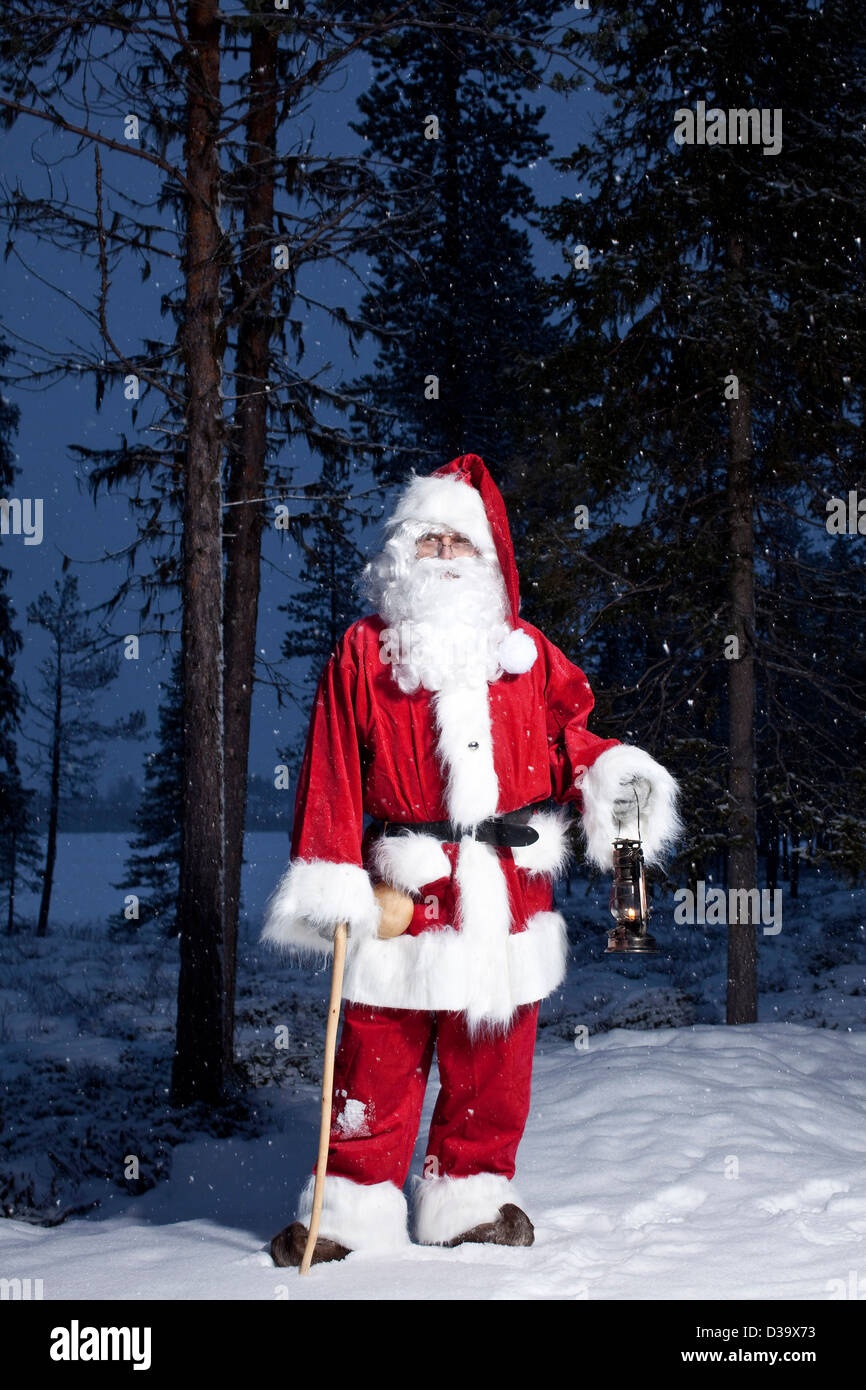 Man in father christmas costume with lantern, Lapland Stock Photo