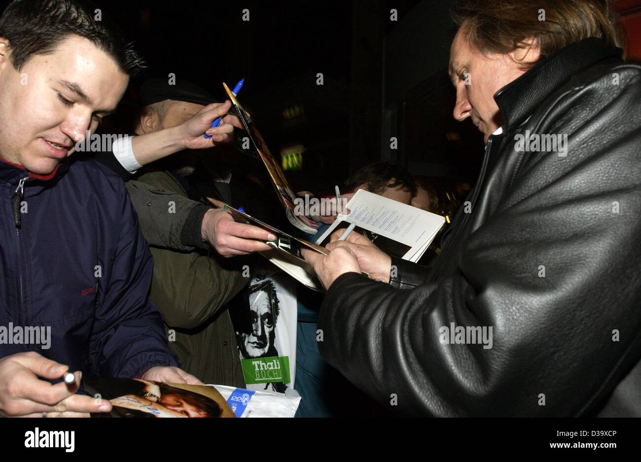 (dpa) - French actor Gerard Depardieu (r) gives autographs to fans as he arrives to the German first night screening of his new film 'Asterix & Obelix - Mission Cleopatra' in Hamburg, 1.3.2002. 53-year-old Depardieu who stars again as Obelix said the two of them have much in common: Both love to eat Stock Photo