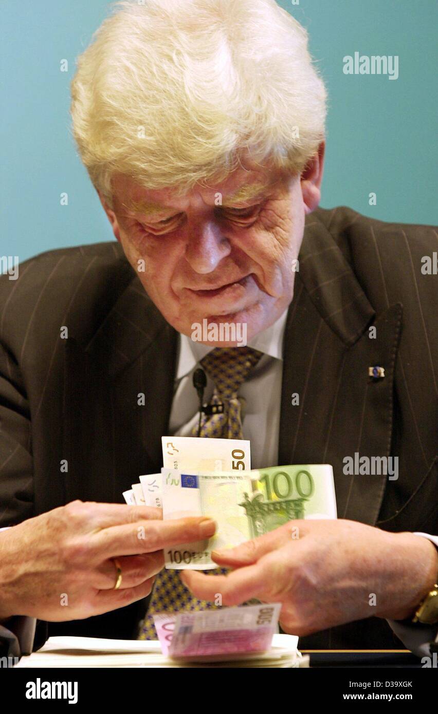 dpa) - Wim Duisenberg, president of the European Central Bank (ECB), sorts  his Euro banknotes from his private purse during a press conference in  Frankfurt, 31.12.2001. Duisenberg wished a good start for