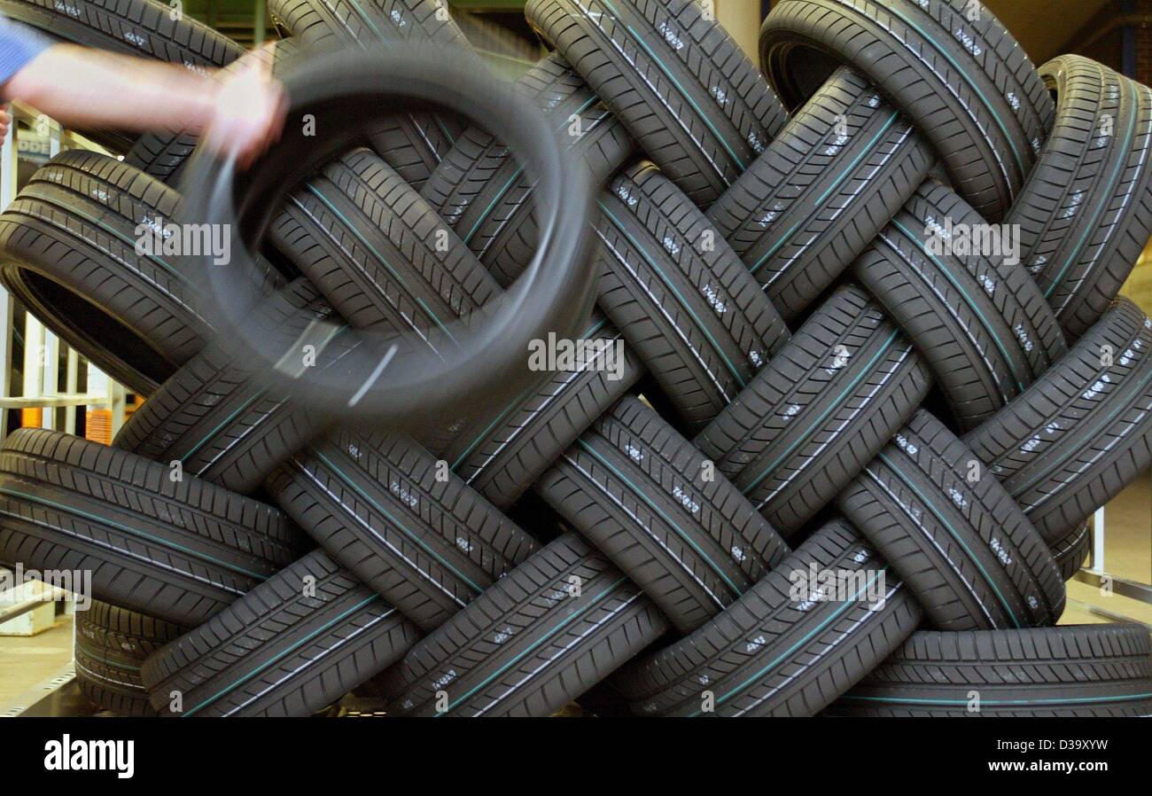 dpa files) - The hand of an employee of Continental AG, manufacturer of car  tyres, throws a car tyre onto a pile of other car tyres at the production  plant in Hanover,