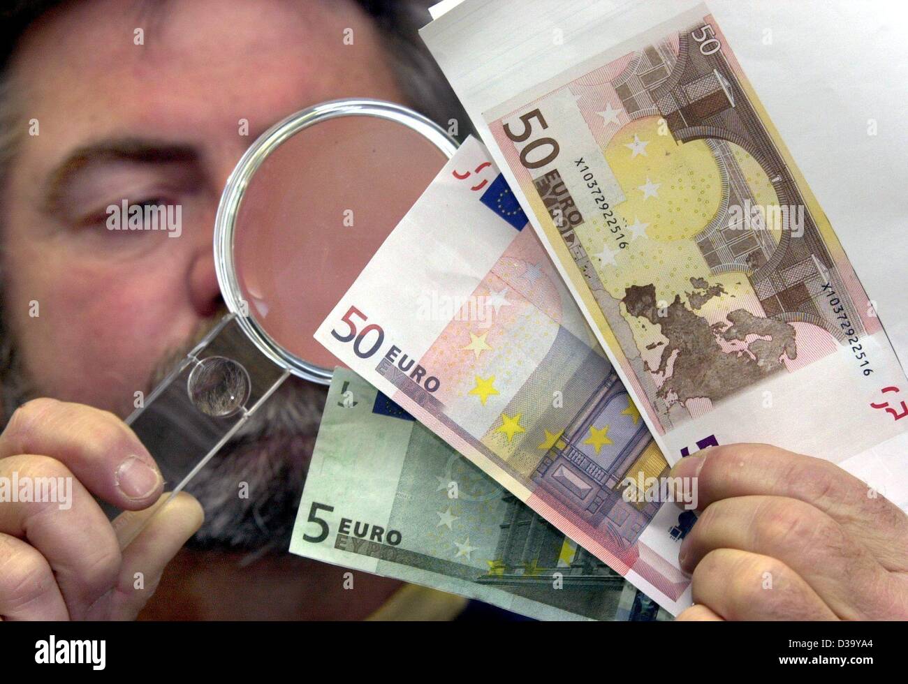 (dpa) - A detective of the Bavarian police checks false Euro banknotes in Munich, 10.1.2002. They had simply been scanned an printed from a computer. January 1st, 2002 marked the official date for the launch of the Euro as common currency for 300 million citizens in twelve European states: Belgium,  Stock Photo