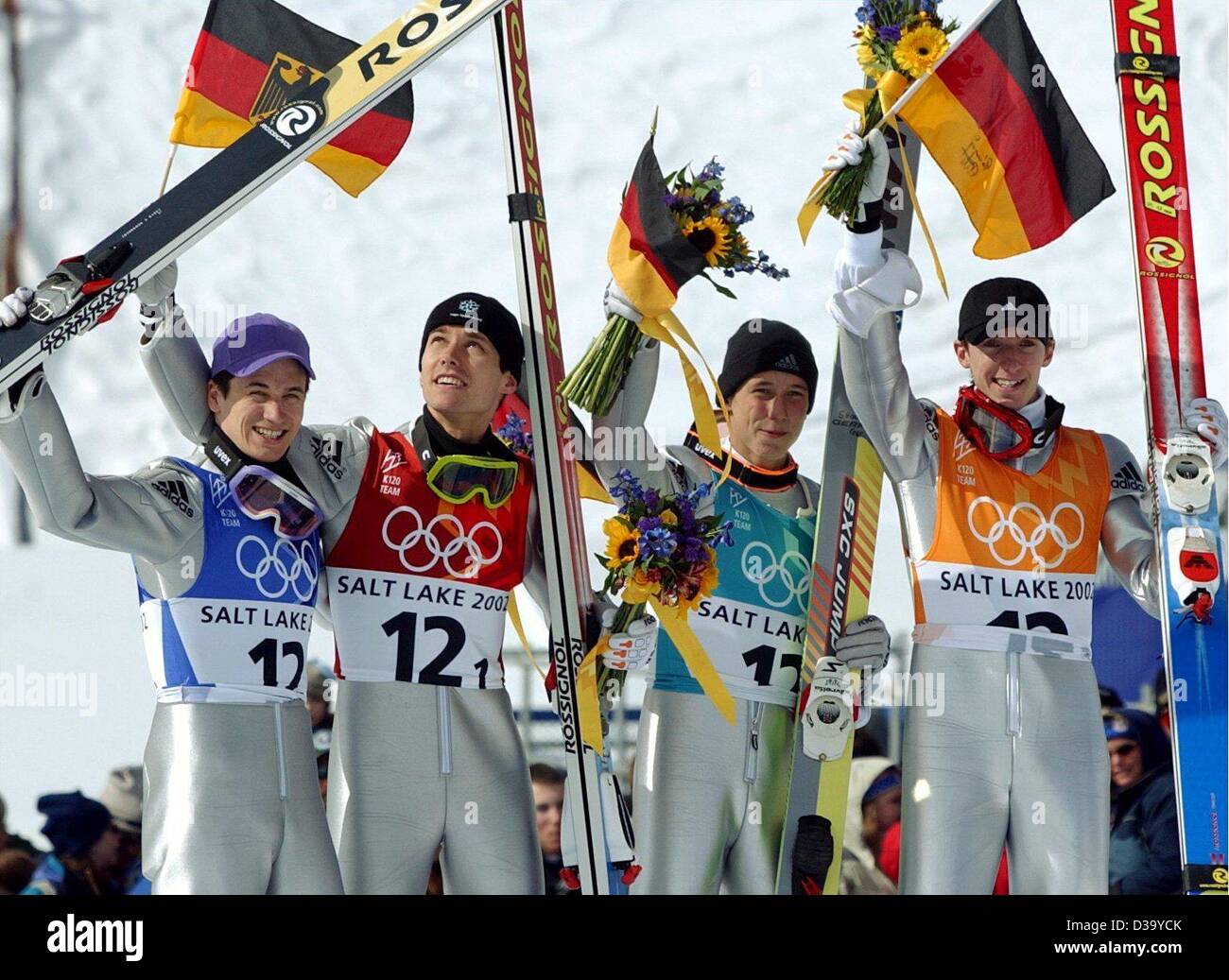 (dpa) - XIX Winter Olympic Games: The German K120 Ski-jumping team, (l-r) Martin Schmitt, Sven Hannawald, Stephan Hocke and Michael Uhrmann, celebrate their victory waving flags, flowers and their ski during the flower ceremony at the Utah Olympic Park, 18.2.2002, at the Olympics in Salt Lake City.  Stock Photo