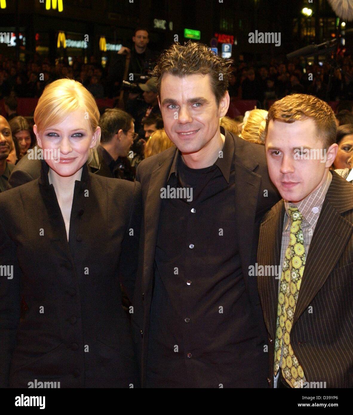 (dpa) - The German director Tom Tykwer (c) arrives with the principal actors of his film 'Heaven', Cate Blanchett and Giovanni Ribisi, at the opening of the 52nd International Film Festival, the socalled Berlinale, in Berlin 6.2.2002. 'Heaven' was the opening screening. Stock Photo