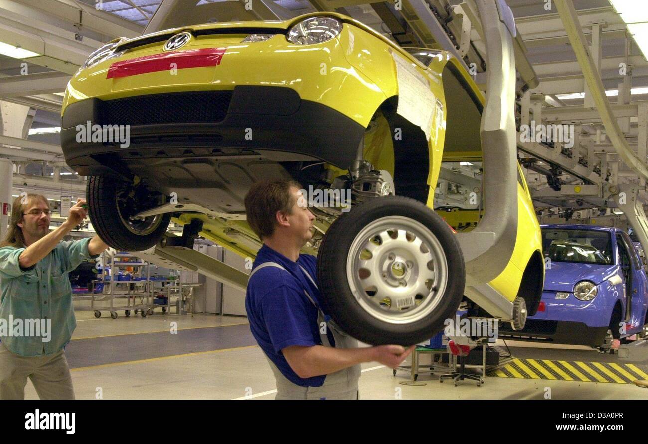 (dpa) - Workers are mounting tyres to the 'Lupo' model at the Volkswagen (VW) plant in Wolfsburg, Germany, 18 February 2002. Stock Photo