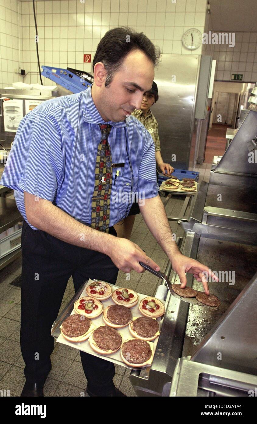 (dpa) - An employee of the US fast-food supplier McDonald's is preparing hamburgers in the kitchen of one of the chain's restaurant in Cologne, 21 April 2002. Stock Photo
