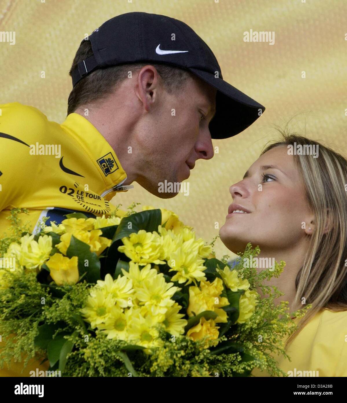 (dpa) - Retaining the yellow jersey US Lance Armstrong of the US Postal Service team kisses a hostess after the 17th stage of the Tour De France from Aime to Cluses, in Cluses, 25 July 2002. Stock Photo