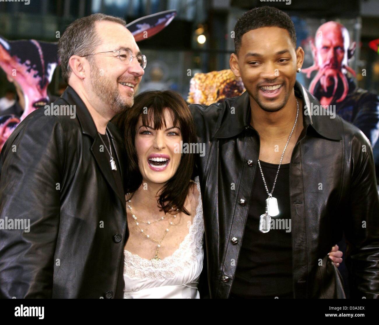 (dpa) - From L-R US film director Barry Sonnenfeld smiles with US actress Lara Flynn Boyle and Will Smith as they arrive for the European premiere of the film 'Men In Black II' at the Sony-Center in Berlin, 11 July 2002. Stock Photo