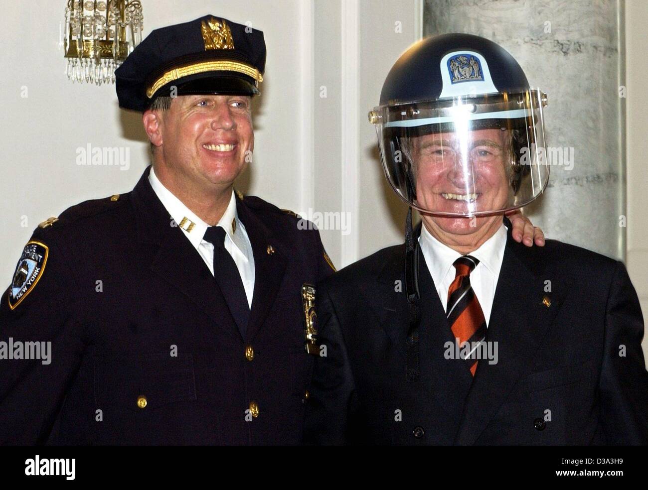 (dpa) - German President Johannes Rau (R) wears a helmet of the New York fire brigade, as he poses with New York police officer Jimmy Albrecht in his residence, the palace 'Bellevue' in Berlin, 20 June 2002. The helmet was a present of the police and firemen, who had worked on Ground Zero on the day Stock Photo