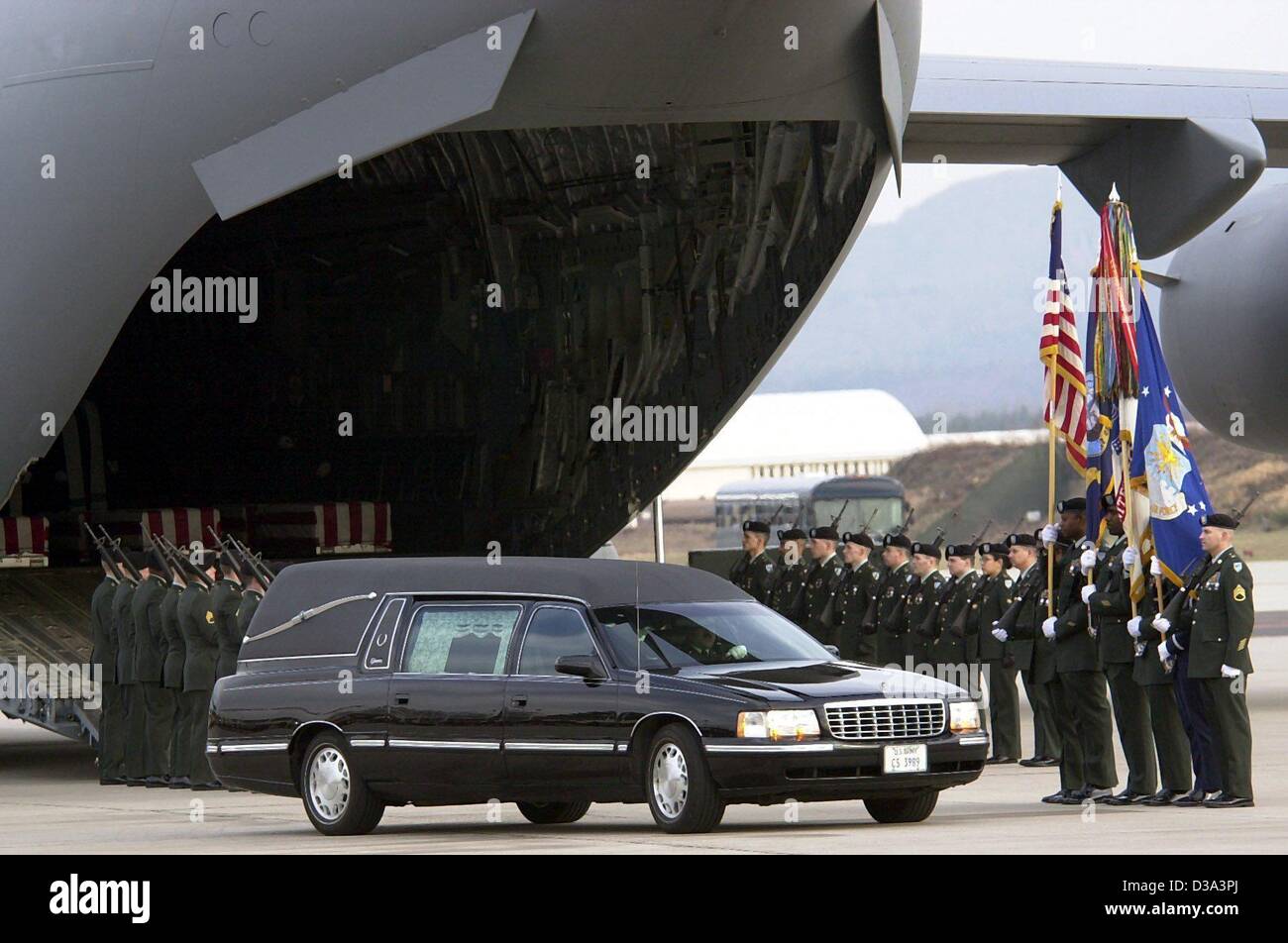(dpa files) - A hearse stands in front of a US aircraft at Ramstein Air Base, Germany, 5 March 2002, while a US Army honor guard pays tribute to the seven US American soldiers killed in a missile attack in Afghanistan the day before. The coffins containing the remains of the soldiers were flown to D Stock Photo