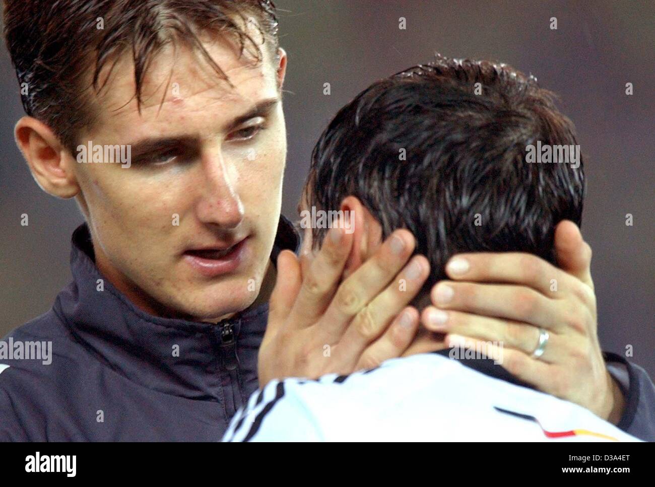 (dpa) - German striker Miroslav Klose (L) comforts his team mate Oliver Neuville after the defeat in the FIFA World Cup final opposing Germany and Brazil in Yokohama, Japan, 30 June 2002. The match ended 2:0 for Brazil, making Brazil a record five-time world champion and Germany winning the 2nd plac Stock Photo