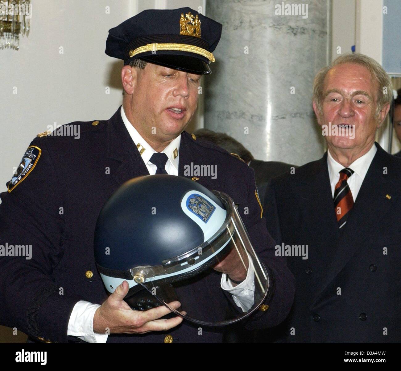 (dpa) - German President Johannes Rau (R) receives a helmet of the New York fire brigade from New York police officer Jimmy Albrecht, in his residence, the palace 'Bellevue' in Berlin, 20 June 2002. The helmet was a present of the police and firemen, who had worked on Ground Zero on the day of the 1 Stock Photo